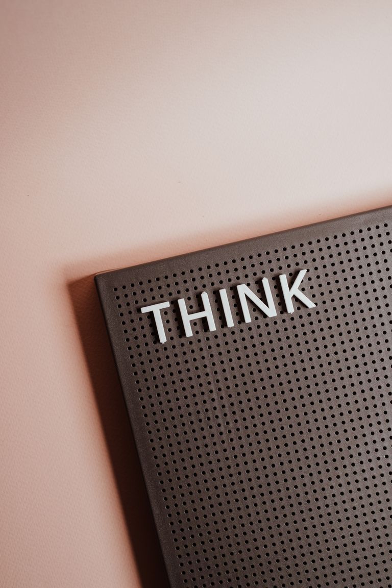 Close-up of a letter board with the word 'THINK' on a soft background.